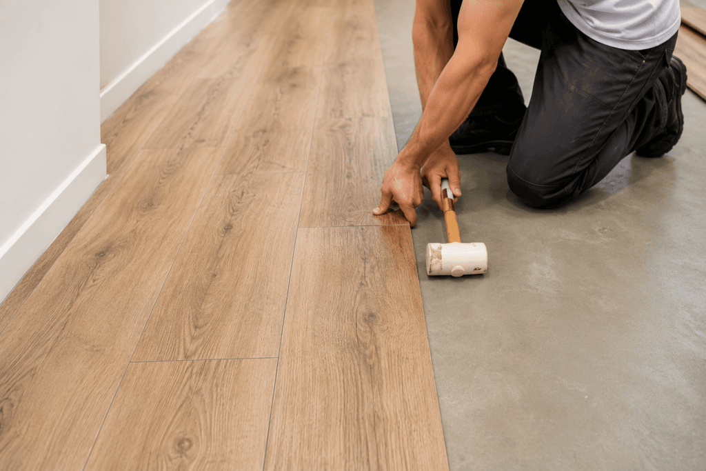 Profissional instalando piso vinílico clicado em contrapiso nivelado